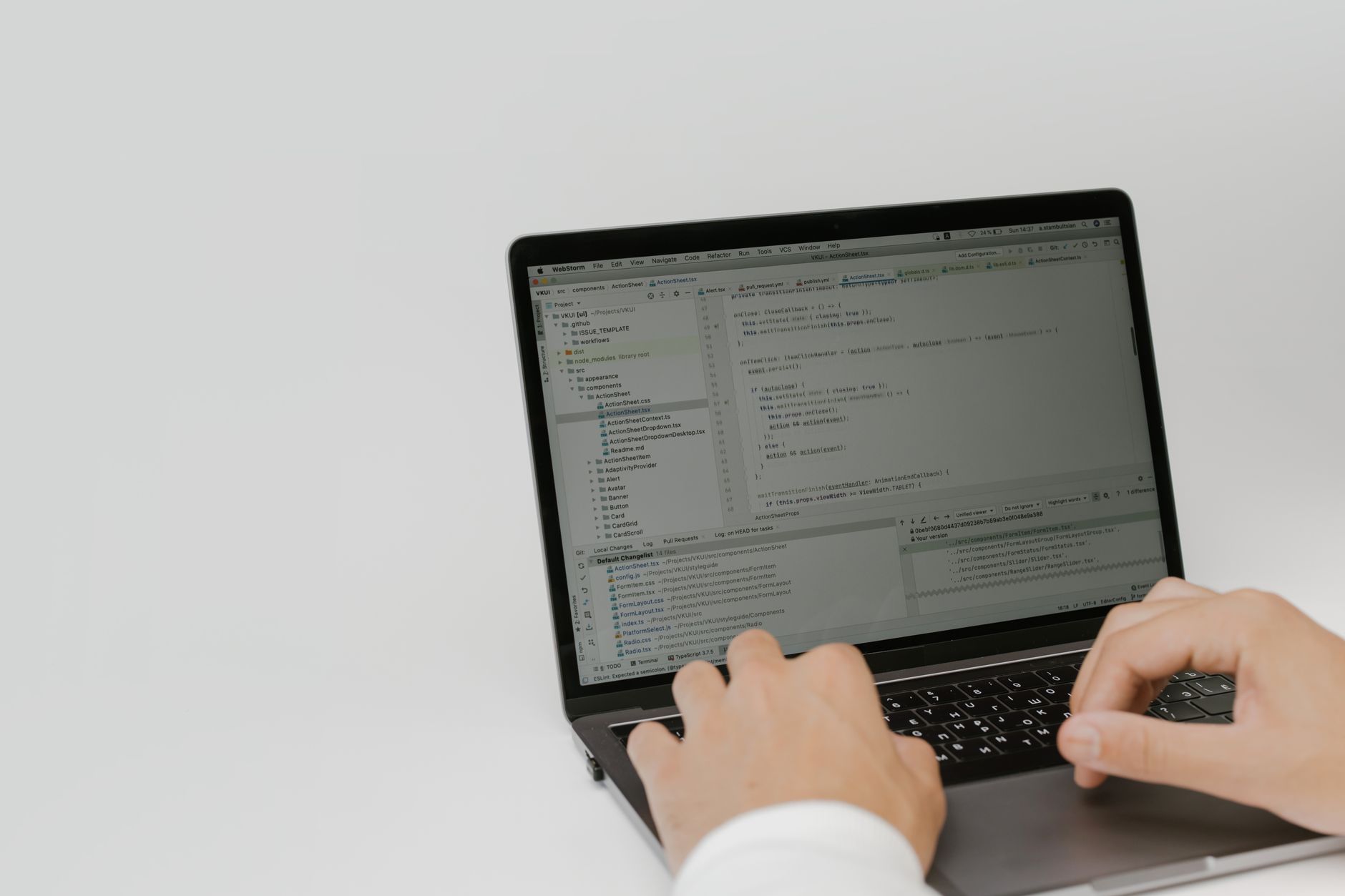 Developer using a laptop with an AI code editor showing multiple file changes