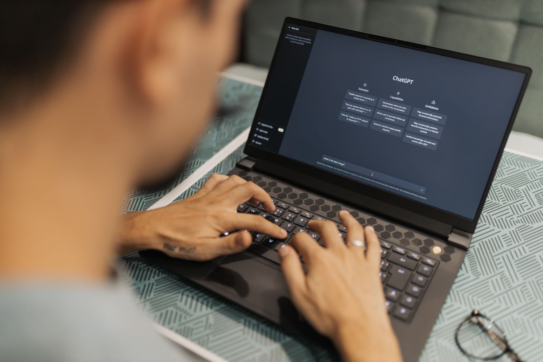 Person typing on a laptop with a clean AI chat interface on screen