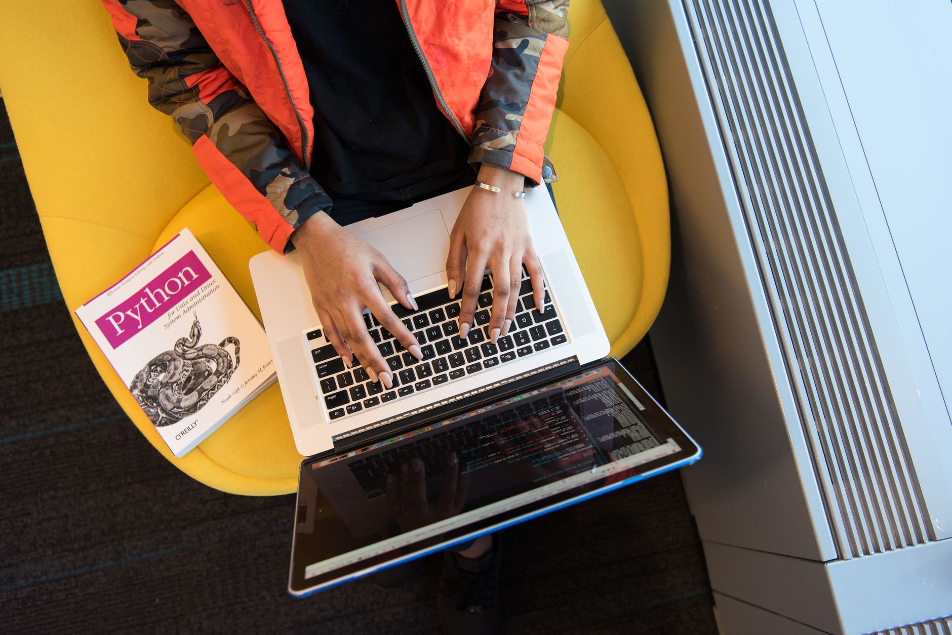 Developer writing Python code on a laptop screen with a code editor open.